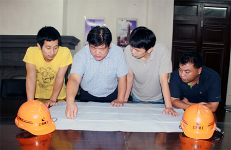 項(xiàng)目經(jīng)理趙明鋒(左二)正在與技術(shù)人員商談施工方案